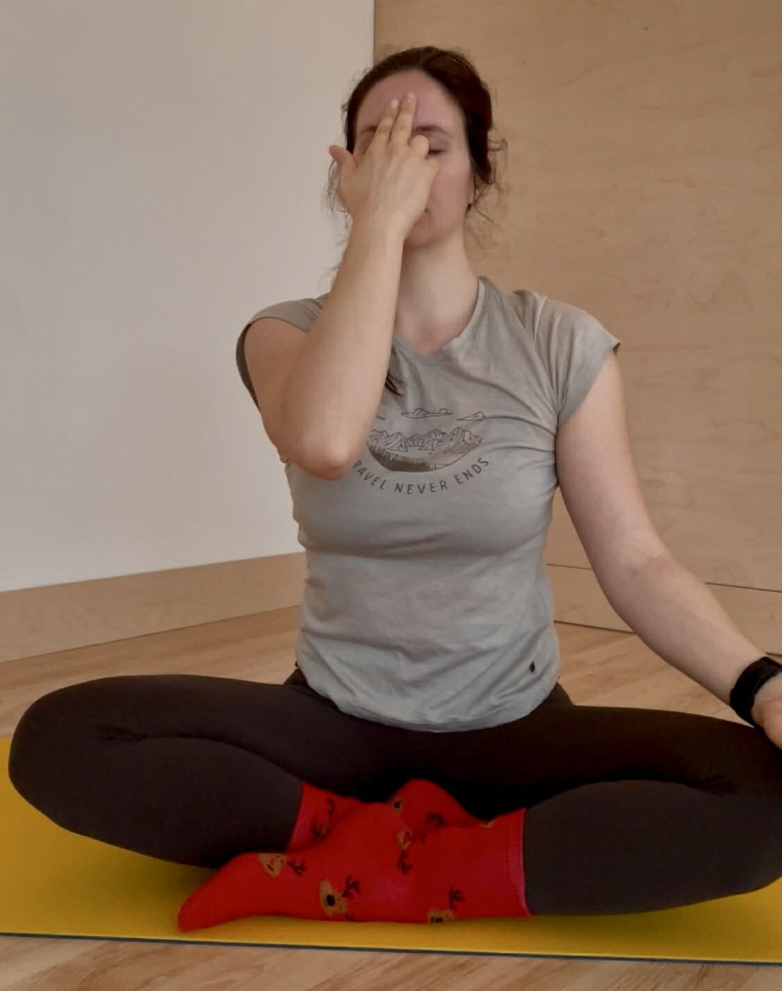 femme assise sur un tapis de yoga, faisant un exercice de respiration
